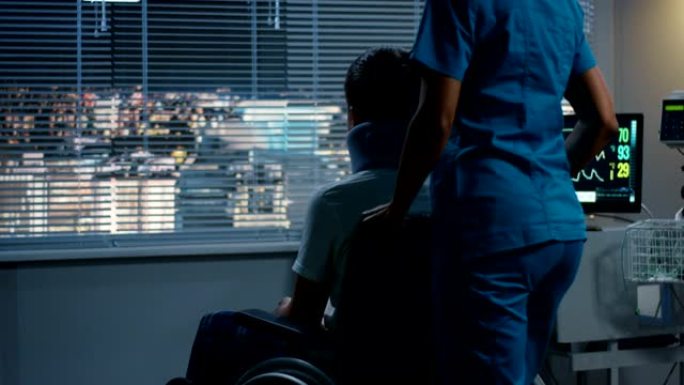 护士将轮椅主持的病人推到窗户上