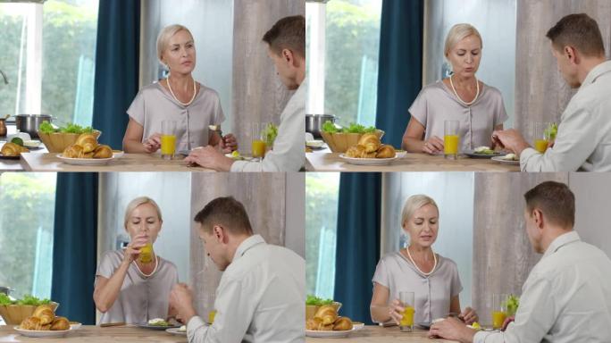 中年白人女士在家与丈夫一起吃早餐