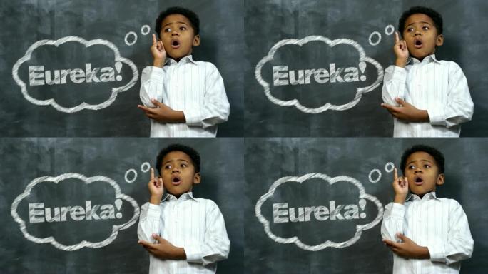 快乐的非洲男孩用尤里卡单词在黑板上发现