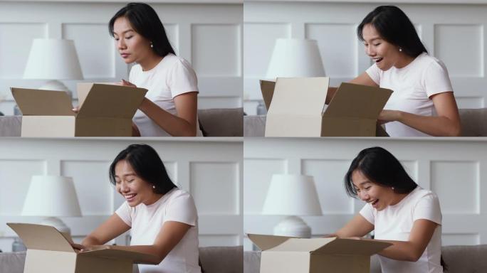 快乐亚洲女孩顾客打开纸箱接收包裹