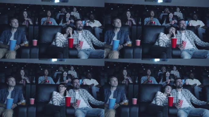 快乐的千禧一代在现代电影院看电影的慢动作笑