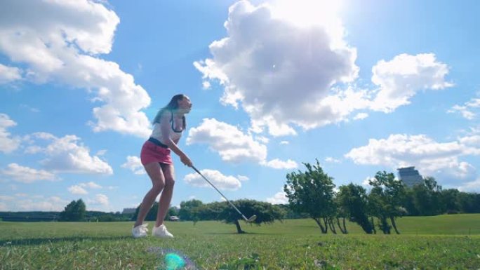 一名女子在高尔夫球场上训练，击球。