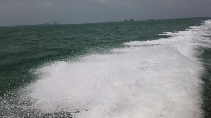 在海浪撞击船之间的公海中，全速行驶的船的镜头