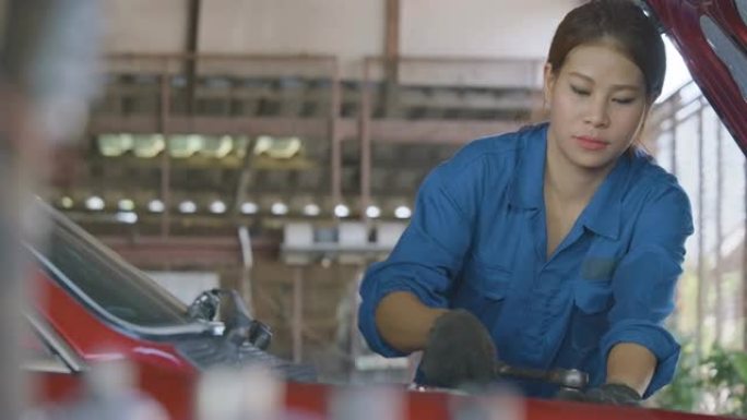 职业女机械师在车库修理汽车。汽车服务理念。