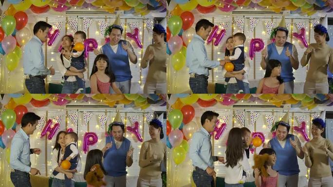 一群年轻的亚洲家庭在家里的派对活动中一起跳舞。快乐的家庭庆祝除夕。