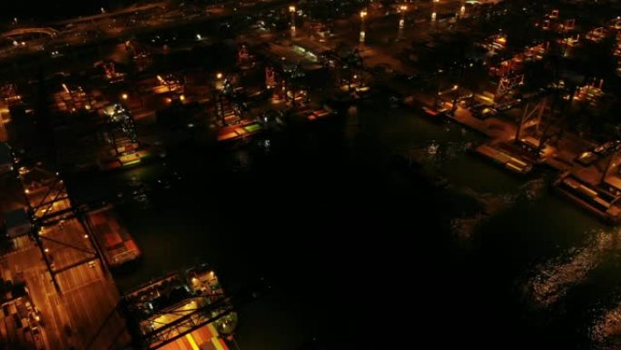 夜间工业港口集装箱船的鸟瞰图和小车权。