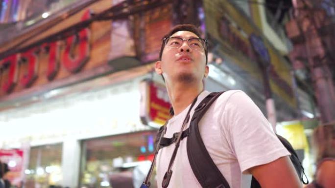 男摄影师在泰国曼谷Yaowarat街头小吃夜市拍摄照片