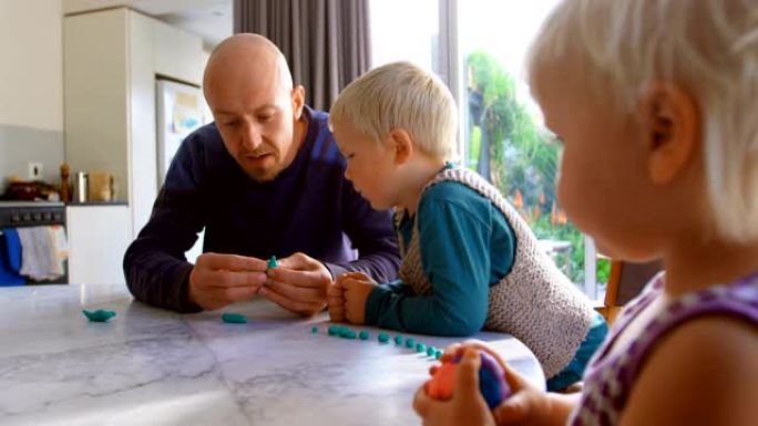 父亲和孩子们在舒适的家庭中与黏土一起玩耍4k