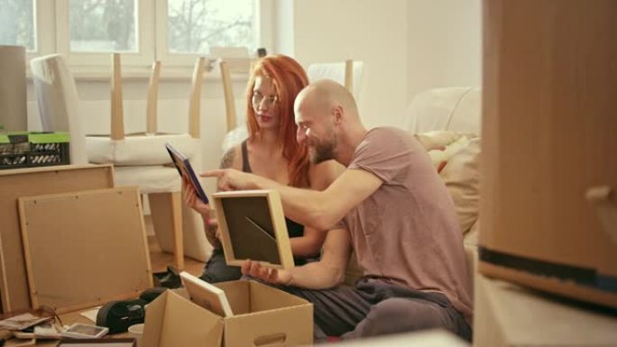 年轻夫妇搬进新公寓。打开纸板箱的包装。