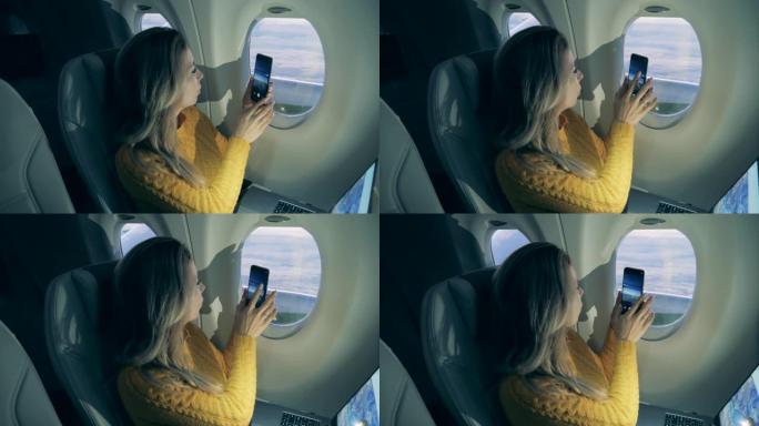 一位女士在飞机上用手机拍照