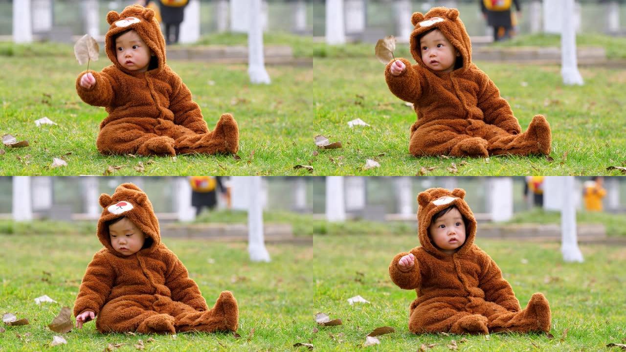 可爱的亚洲小宝宝坐在户外草坪上