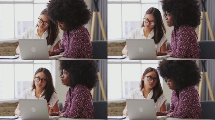 两位千禧一代女性商业创意人士在团队会议上交谈和做笔记，特写