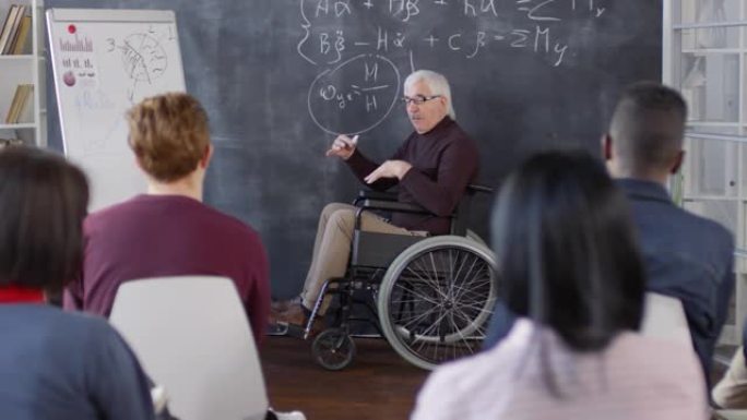 成熟的残疾教授在黑板上写作