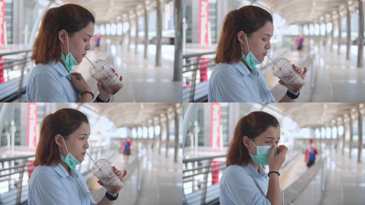女人打开防护面罩喝冰咖啡，慢动作