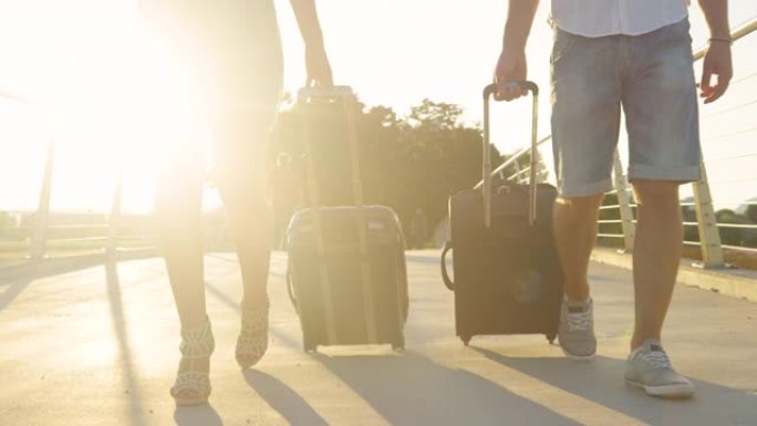 镜头耀斑: 一对夫妇将行李箱拖到机场的电影镜头