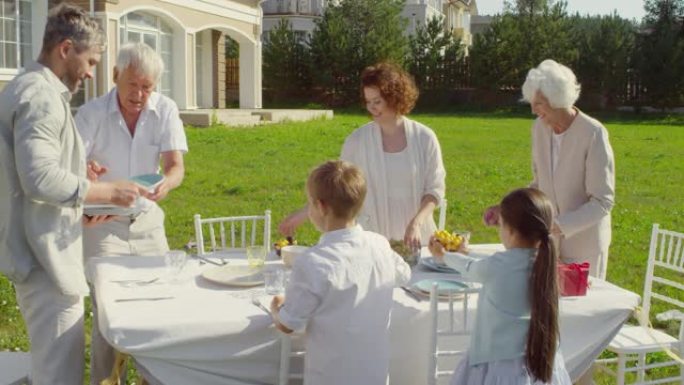 多代家庭为户外生日派对准备餐桌