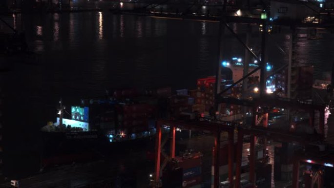 集装箱运输工业港口的4k时间流逝。进出口货物国际业务。大型起重机在夜间将集装箱装卸到卡车上。