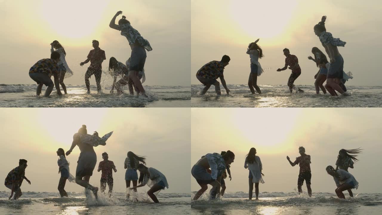 一群年轻的时髦朋友在暑假在海滩上玩水。有旅行、度假和派对概念的人。慢动作