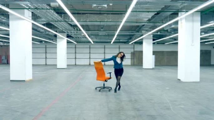 快乐的女店员独自一人坐在椅子上跳舞。