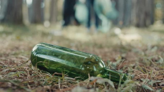 森林地面上的绿色瓶子