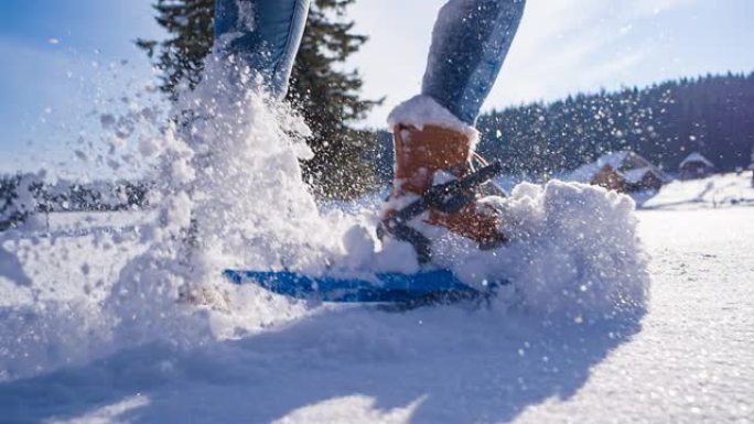 用绑在脚上的雪鞋在新鲜落下的粉末雪上徒步旅行