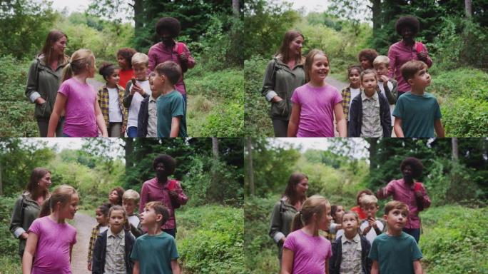 成人团队负责人与一群孩子在户外活动营地漫步在林地中