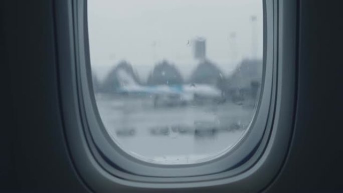 从机场视野的窗户起飞的降雨航班延误