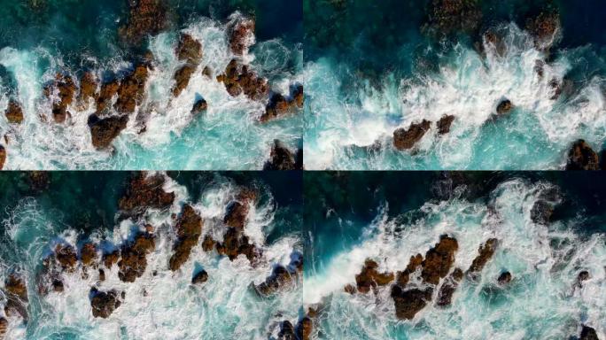 波浪在石头上破碎。海浪起泡和飞溅的海浪。空中俯视图。西班牙特内里费岛。4K, UHD