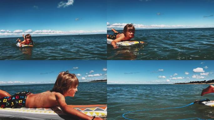 男孩在海上冲浪板上划水