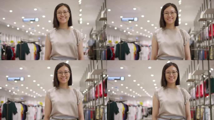 快乐的亚洲女人在服装店摆姿势