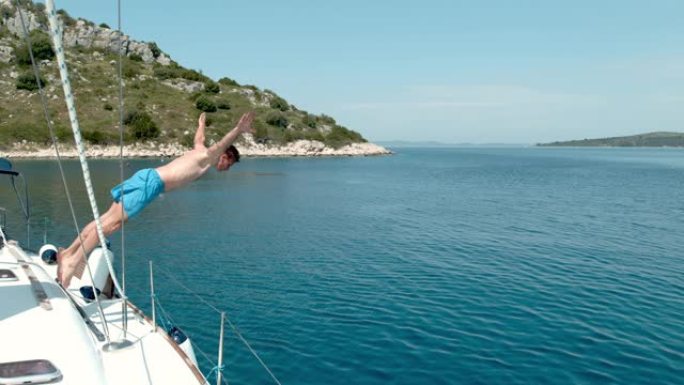 MS超级慢动作，男子从帆船上跳入克罗地亚阳光明媚的蓝色海洋