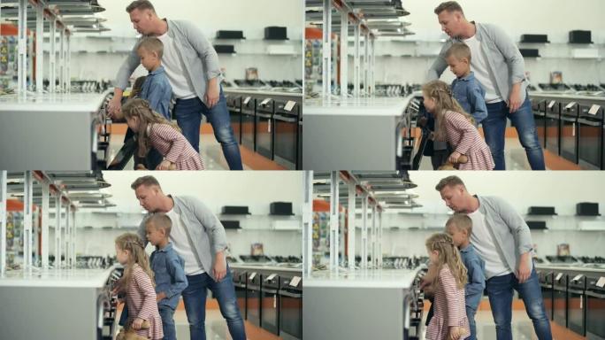 男子带着小女儿和儿子在家电商店购物