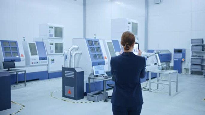 现代工厂: 女工程师使用带有增强现实软件的数字平板电脑来可视化车间的房间地图，楼层布局。具有高科技数
