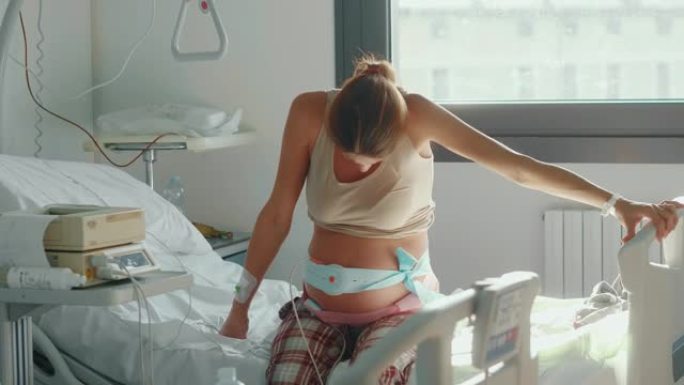 一名年轻孕妇的真实特写镜头在医院的产房分娩前几个小时发生宫缩