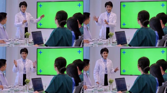医生在会议期间在绿色屏幕上展示，年轻实习生在医学会议期间听医生的演讲。医学教育，医院，保健，医学教育