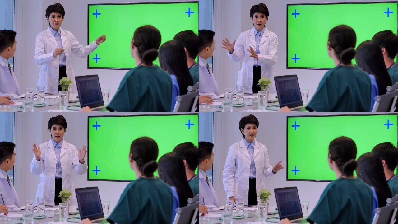 医生在会议期间在绿色屏幕上展示，年轻实习生在医学会议期间听医生的演讲。医学教育，医院，保健，医学教育