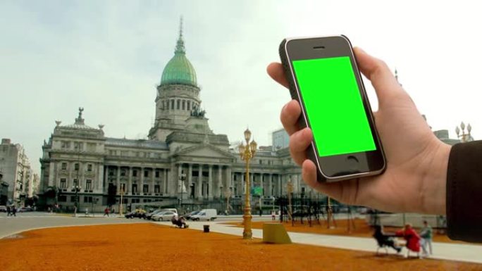 阿根廷布宜诺斯艾利斯，在阿根廷国民大会附近，男性手拿着一部绿屏旧智能手机。