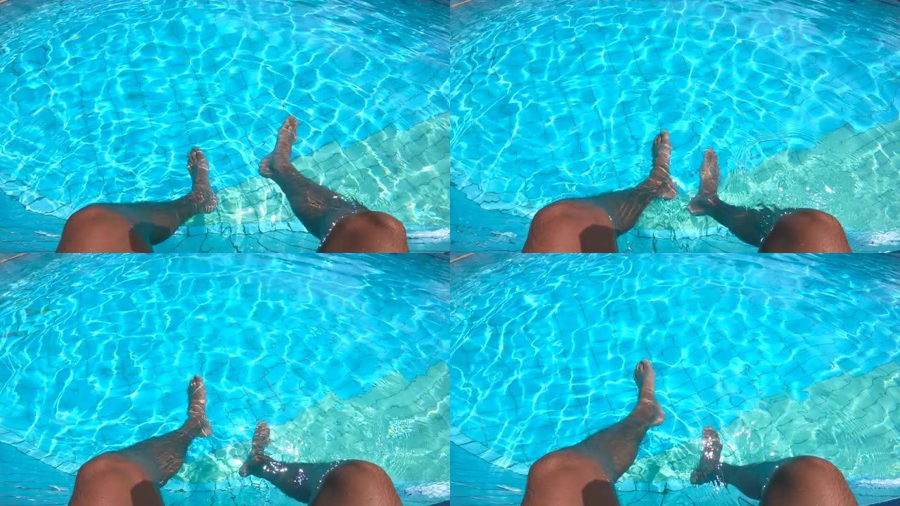 游泳池的水和男性的腿在里面摆动