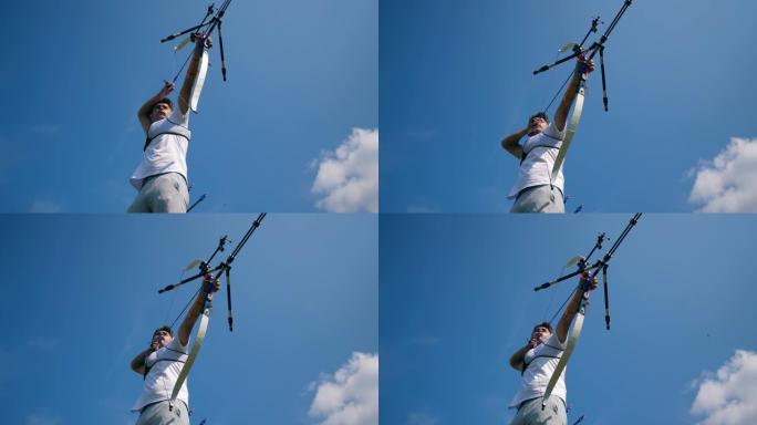 蓝色的天空和从弓瞄准的男性弓箭手