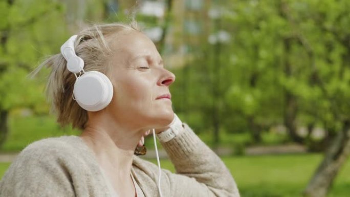 女人在公园里放松和听音乐