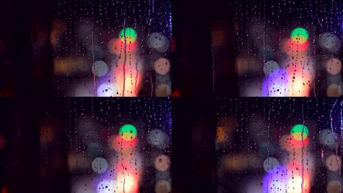 夜间从玻璃窗落下的雨滴