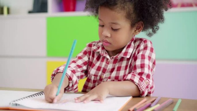 非洲孩子在教室里画画和做作业，年轻女孩在小学快乐有趣的学习和在纸上画画。孩子在学校画画的概念。