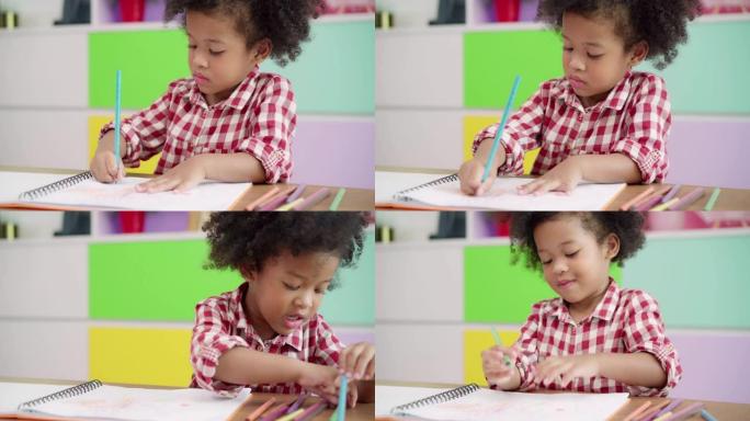 非洲孩子在教室里画画和做作业，年轻女孩在小学快乐有趣的学习和在纸上画画。孩子在学校画画的概念。