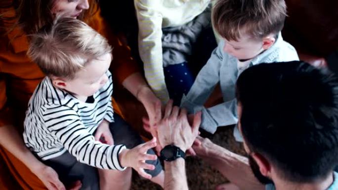 俯视图特写年轻开朗的高加索家庭与三个孩子携手共进，享受一起慢动作的时光。