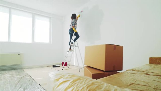 年轻女子粉刷她的新公寓。