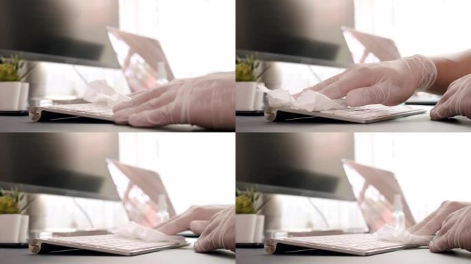 亚洲男子使用消毒湿巾清洁笔记本电脑清洁和抗菌冠状病毒或新型冠状病毒肺炎问题在家里的客厅，同时检疫情况
