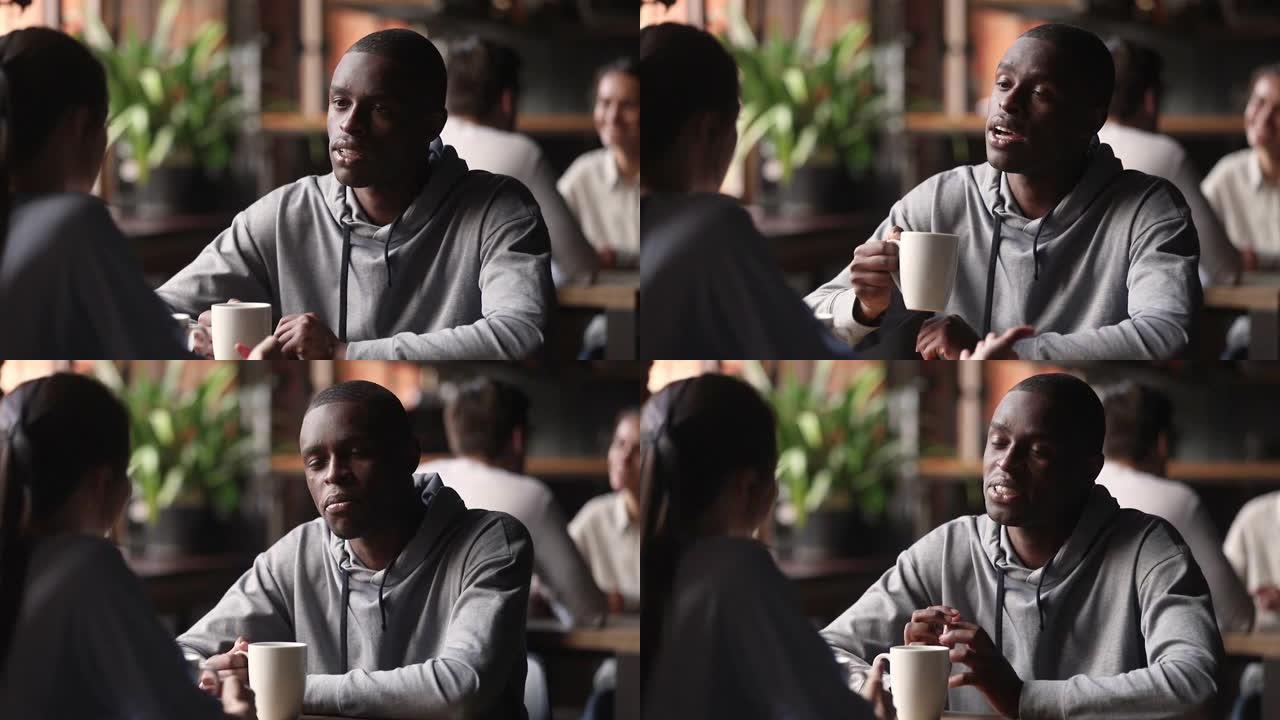 非洲男子在会议上喝茶与白人妇女交谈