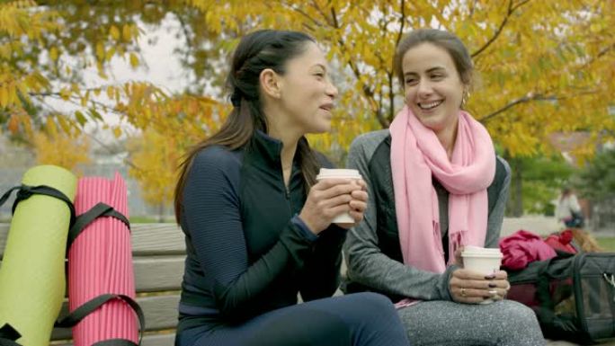 成年女性朋友在公园长椅上喝咖啡