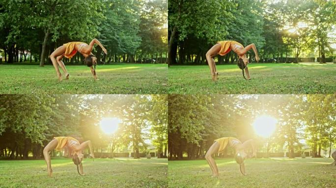 女士灵活的年轻女子练习瑜伽，在阳光明媚的公园里使用智能手机颠倒