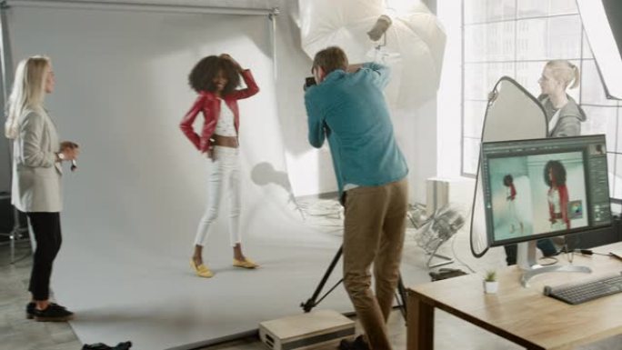 迷人的黑人女孩，郁郁葱葱的卷发摆姿势拍摄时尚杂志照片。著名摄影师拍摄的照片。美丽的女孩调皮地微笑。在